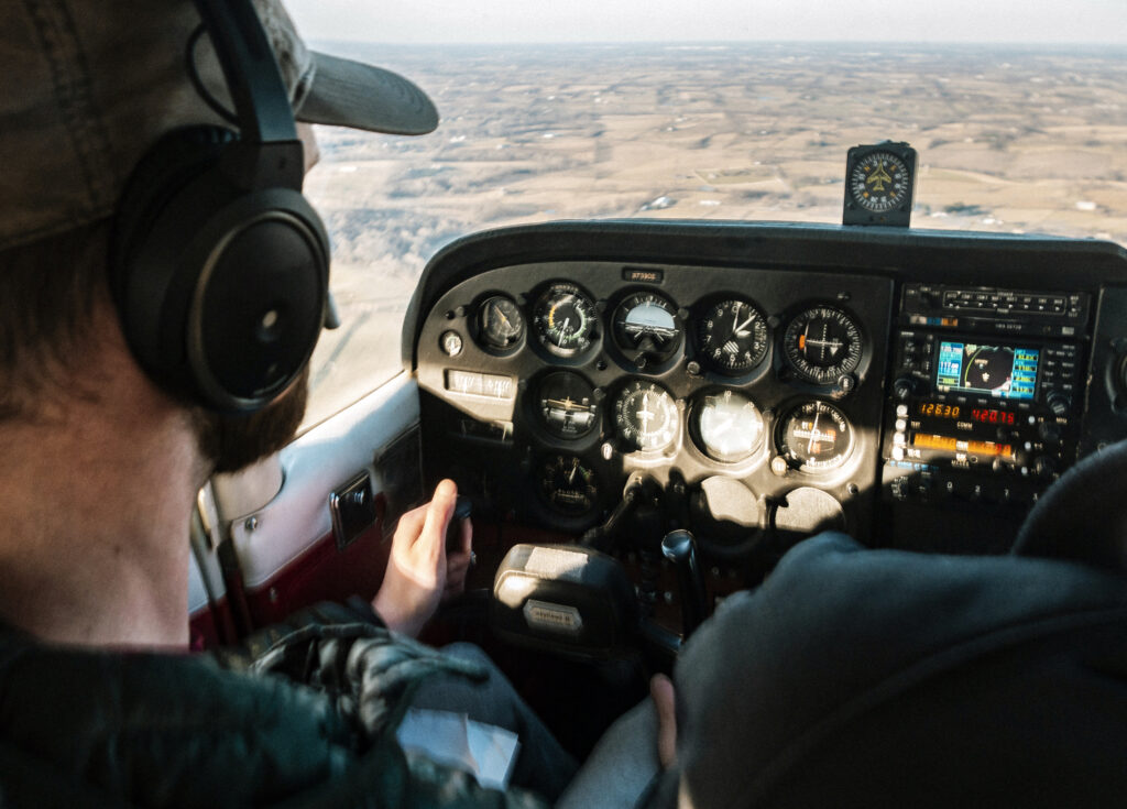 Um homem branco aparece no canto esquerdo. Ele está pilotando um avião.